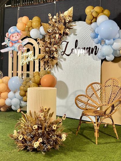 For Zohaan's first birthday, we designed a sophisticated yet adorable pilot teddy bear theme. The decor features a neutral color palette, dried floral arrangements, a stylish rattan chair, and a cute bear-in-a-plane cutout.