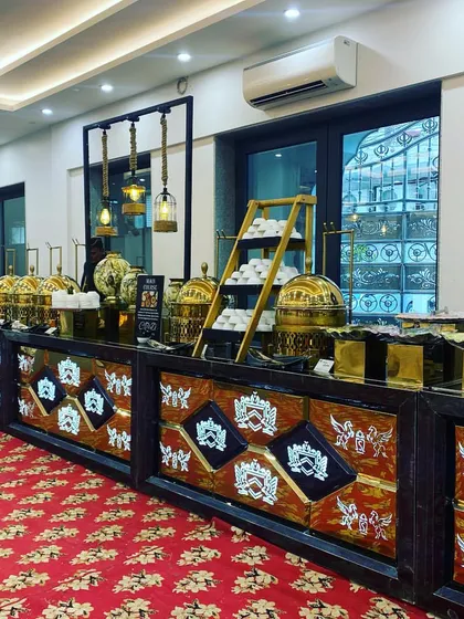 A buffet setup for a luncheon at Vivek Vihar. The intricately designed counters are paired with a vibrant red carpet, showcasing our ability to adapt our decor to match the venue's aesthetic.