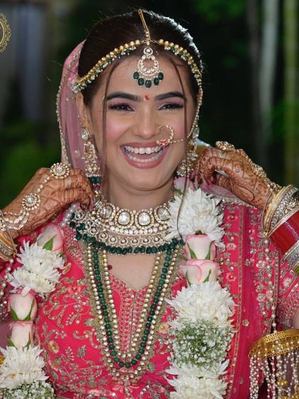 The smile on our client's face is our greatest reward. This happy bride is wearing a complete Kundan and emerald bead bridal set, all rented from our collection.