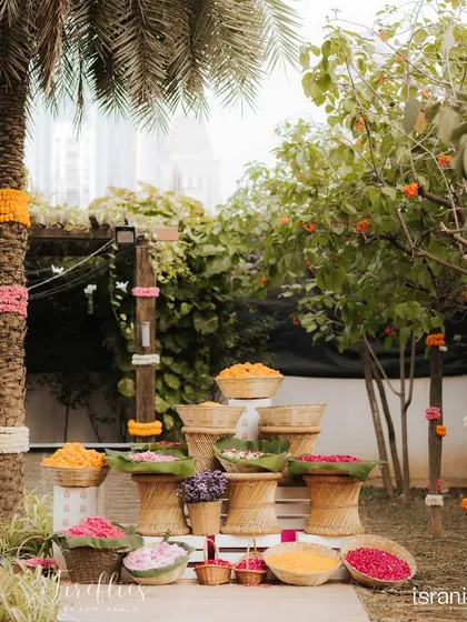 An installation of traditional cane baskets ('tokri') and 'mooda' stools, filled with an abundance of colorful fresh flowers. This corner celebrated rustic Indian craftsmanship.