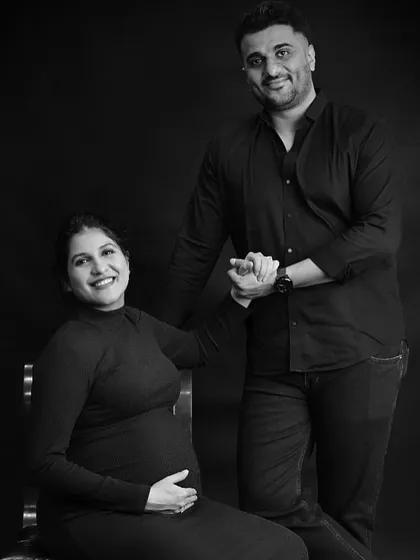 A happy black and white portrait of the expecting couple in the studio.