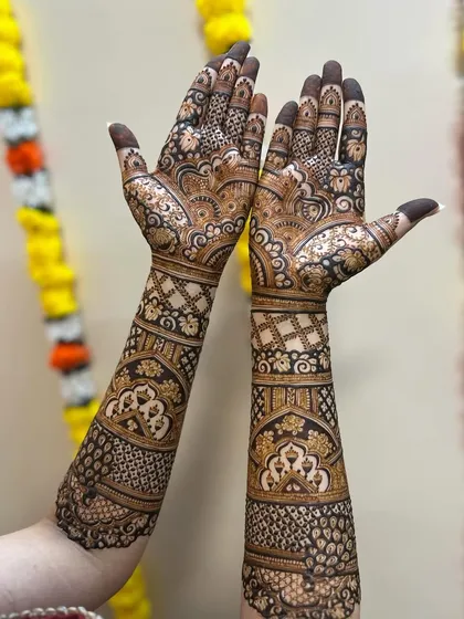 A beautiful bridal design with a mix of paisleys, florals, and geometric patterns. The symmetry in the design creates a harmonious and balanced look, perfect for a wedding.