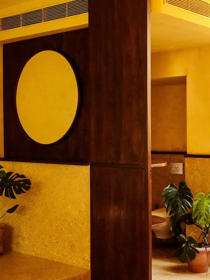 The clean, minimalist design extends to every corner, with potted monstera plants adding a touch of vibrant green.