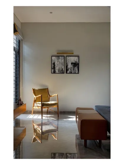 Sunlight streams into a bedroom in the "Solid | Void | Solid House," reflecting off the polished floor. We carefully consider the movement of light to create dynamic and comfortable interior spaces.