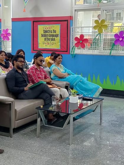 A wider view of the judging panel at a school event. The school's colorful decor added to the cheerful atmosphere.
