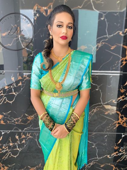 The complete engagement look, showcasing the vibrant saree and bold makeup. The combination of a classic red lip and traditional gold jewellery creates a powerful and beautiful statement.