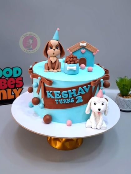 A cute puppy-themed cake for Keshav's 2nd birthday, with two adorable fondant dogs and a doghouse.