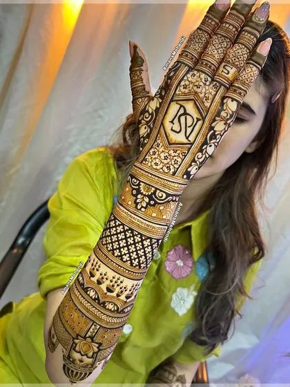 I love creating personalized mehendi, like this full-arm bridal design featuring the couple's initials, 'N' and 'V'. It's a beautiful way to make your wedding henna uniquely yours.