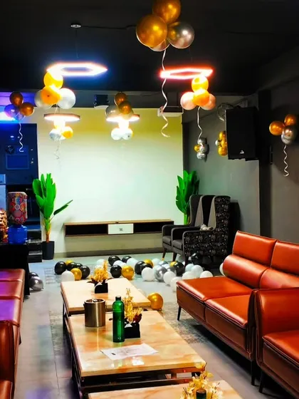 A lounge setup with gold, silver, and white balloons. The lighting and balloon placement create a sophisticated yet fun atmosphere for an evening party.