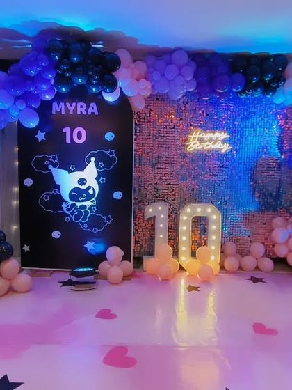 A cool and edgy Kuromi-themed party for Myra's 10th birthday. The setup features a dark color palette with pink and purple accents, character cutouts, a sequin wall, and a marquee number '10'.