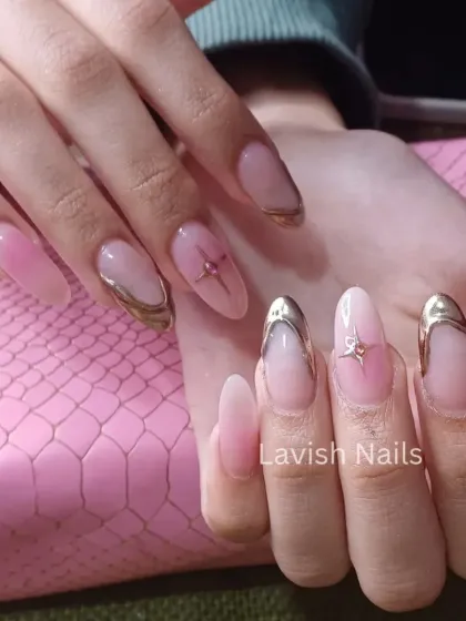 An elegant version of the chrome-tipped French manicure on long, oval nails with subtle star and bow accents.