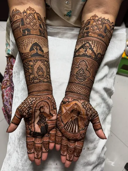 This design combines a portrait of a dancing bride with traditional Rajasthani elements. Notice the detailed elephants and architectural jharokhas on the forearms, blending personal storytelling with classic motifs.