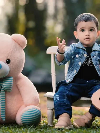 A little musician and his teddy bear enjoying an outdoor session. I use props like this toy guitar to encourage playful interactions and capture genuine smiles.