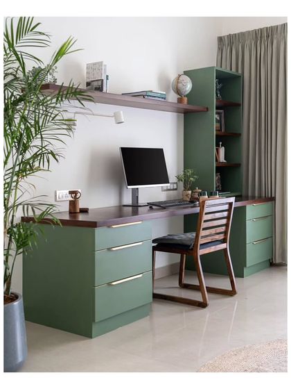 The main work-from-home desk in the study, combining a rich walnut top with olive green drawers. The spacious desk and ample natural light make it a comfortable and inspiring workspace.