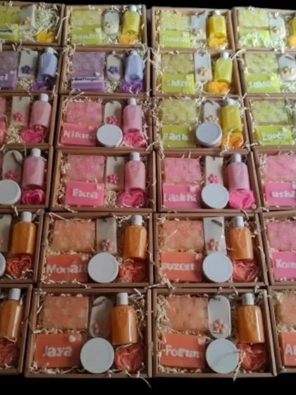 An overhead view of a large batch of personalized corporate gift hampers, each with a unique name and color theme.