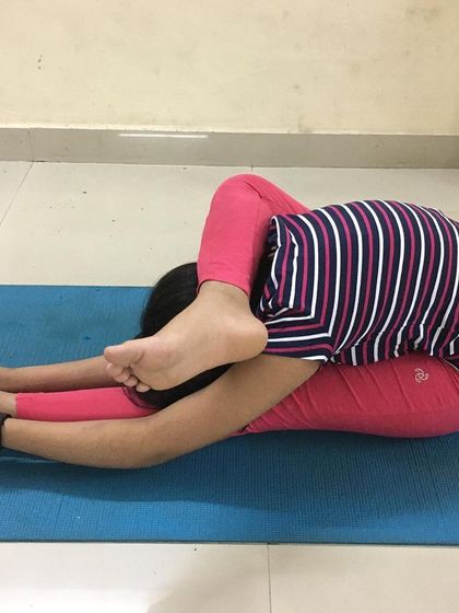 A student practices the complex Buddhasana (Awakened Pose). This asana requires significant hip and shoulder flexibility and builds great core stability.