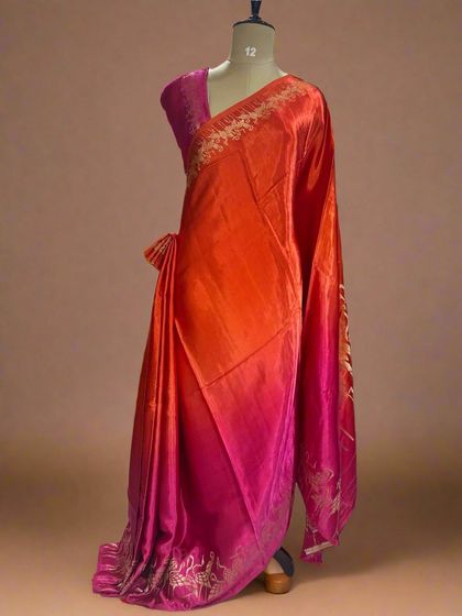 A vibrant shaded satin crepe saree with a flamingo border, blending from orange to pink.