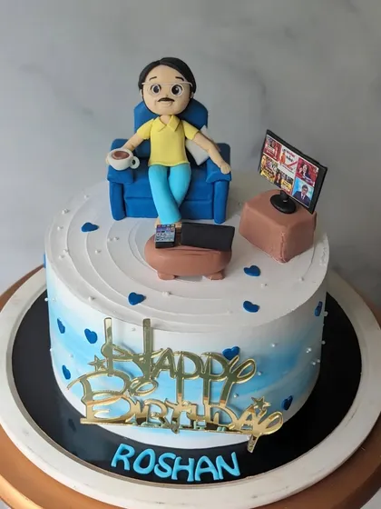 A theme cake ordered by a wife for her husband's birthday. It shows him relaxing with a cup of tea and watching TV, capturing a perfect moment of downtime.