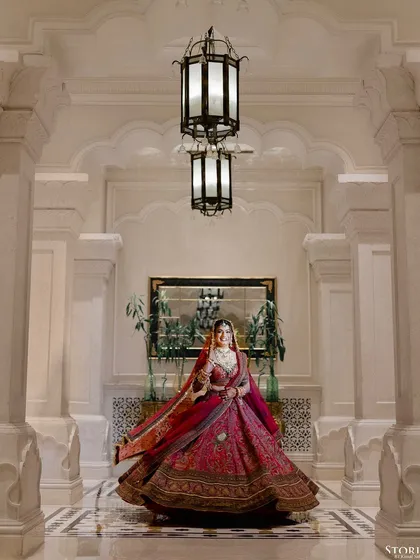 A beautiful full-length portrait of the bride, Kritika, twirling in her lehenga in a grand hotel corridor.