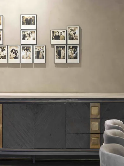 The ground floor family lounge at the Bammi Residence, where a custom sideboard by Furgonomics is paired with a gallery wall of family photos. The design creates a space that is both stylish and deeply personal.