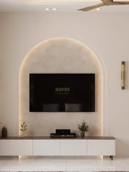 The TV unit in the Scandinavian master bedroom is set within an arched niche, continuing the design motif. The console is simple and modern, and the wall is flanked by elegant sconce lights.
