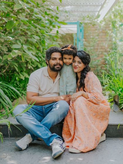 A happy family portrait in a beautiful outdoor setting. The natural greenery provides a stunning backdrop.