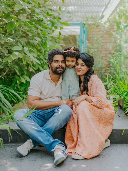 A happy family portrait in a beautiful outdoor setting. The natural greenery provides a stunning backdrop.