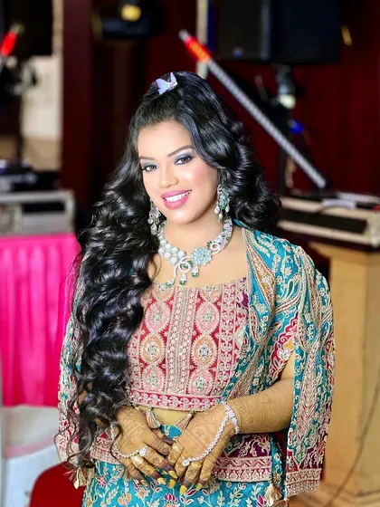 A happy, smiling portrait of the bride-to-be, ready for her party. The half-up hairstyle and sparkling jewellery complete her festive look.