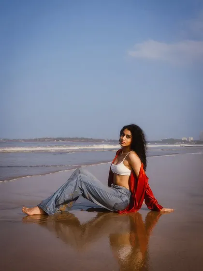 A wide-angle shot showing the vastness of the beach and the beautiful reflection on the wet sand. This creates a sense of calm and solitude.
