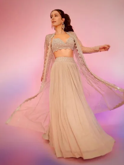 The full view of this Rishi and Soujit outfit shows the flowing pleated skirt and embroidered jacket, creating a graceful and contemporary silhouette.