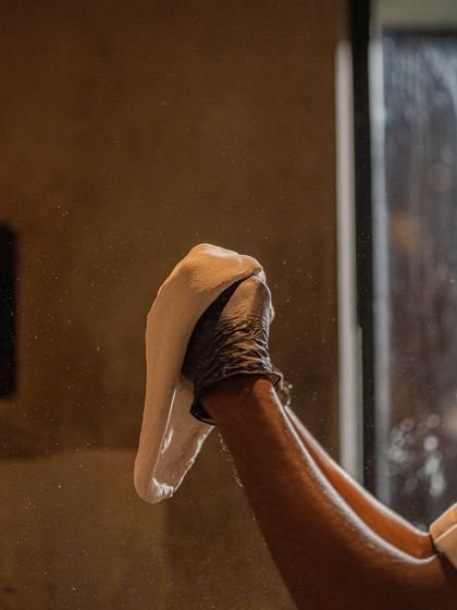 A close-up of a chef's hands expertly shaping the edge of a whole wheat pizza base. This ensures the crust will puff up beautifully in the oven.