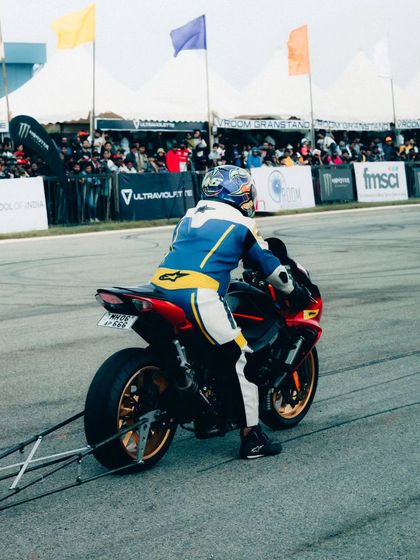 A rider in full race gear launches their superbike off the line. The focus and determination are palpable, capturing the competitive spirit of the event.