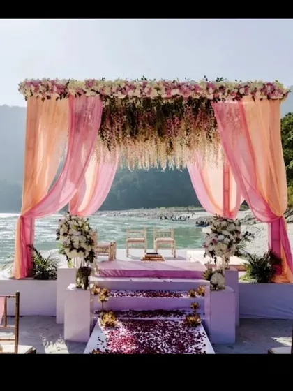 A beautiful mandap on the banks of the Ganga in Rishikesh. The pink drapes and hanging floral chandeliers create a romantic setting for a destination wedding.