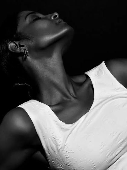 An expressive black and white shot focusing on the elegant line of the model's neck and shoulders.