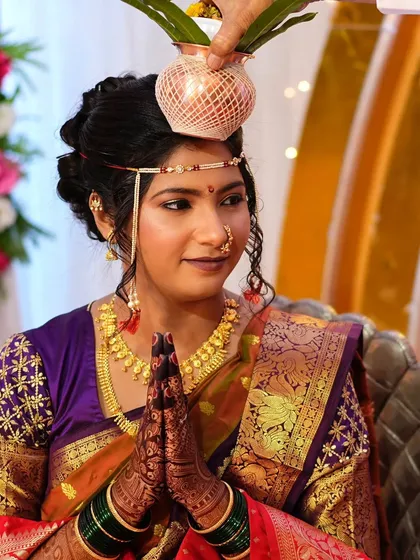 A moment of prayer during the wedding rituals. The bride's makeup is serene and elegant, perfectly suited for the solemnity of the occasion.