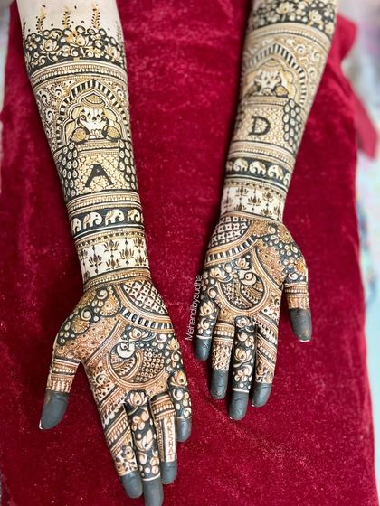 This bridal design features the couple's initials 'A' and 'D' prominently on the forearms, along with traditional jharokha and elephant motifs.