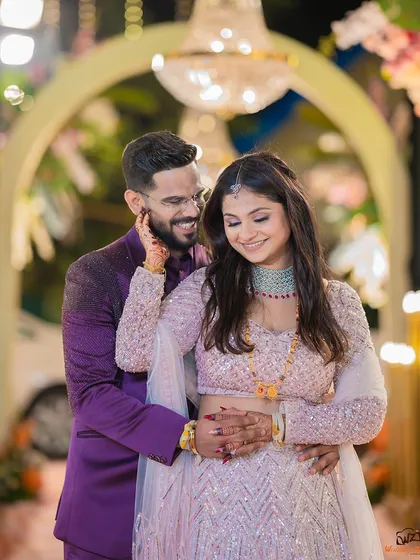 A sweet and romantic portrait from a reception, with the groom gently holding the bride's face as they share a smile.