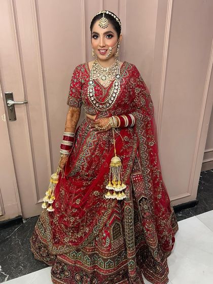 A full-length view of the bride in her stunning red lehenga. The entire look is cohesive and absolutely breathtaking.