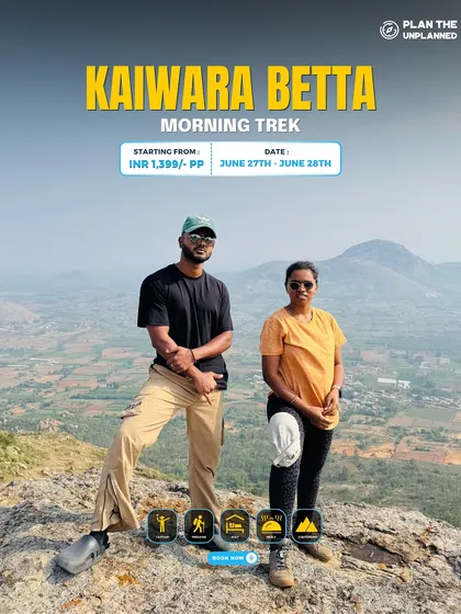 A couple poses on the Kaiwara Betta morning trek, with panoramic views behind them.