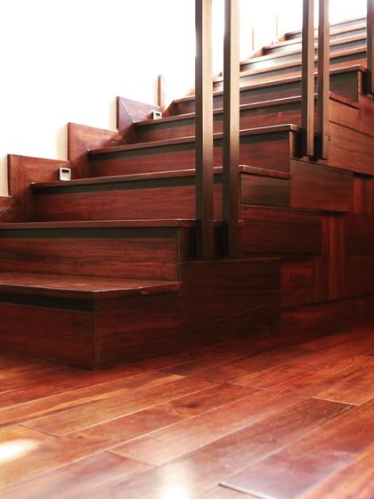 The rich, polished wood of the staircase and flooring at Overseas Traders creates a warm and inviting atmosphere.