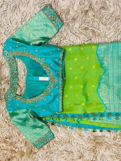 The back of the seafoam blue blouse, featuring a keyhole cutout and intricate embroidery, paired with the parrot green saree.