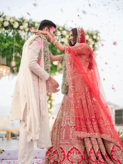 An intimate moment during the Varmala ceremony, as the bride playfully places the garland on the groom.