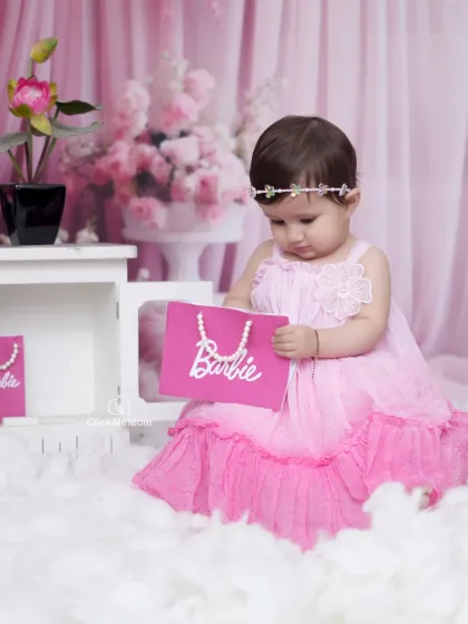 Pretty in pink for her Barbie-themed photoshoot. This little girl looks so sweet and gentle holding her Barbie bag in our floral studio setting.