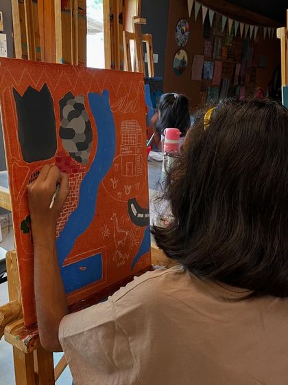 A student works on the bold outlines of her Hockney-style landscape, a key element of his distinctive visual language.