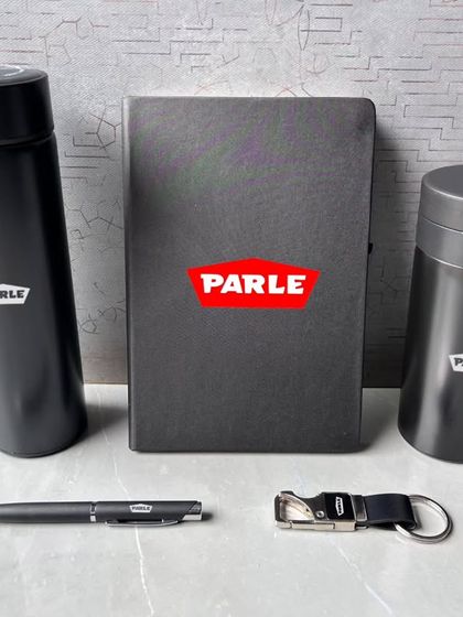 The items from the Parle corporate gift set displayed outside the box. You can see the consistent branding across the temperature flask, diary, travel mug, pen, and keychain.