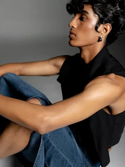 A relaxed yet styled menswear shot for a Calvin Klein campaign. The image uses controlled studio lighting to create a modern, clean aesthetic that focuses on the apparel.