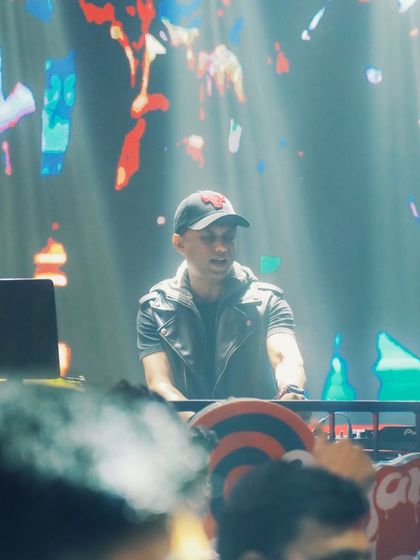 A shot of me at the console, surrounded by light and smoke. The abstract visuals on the screen behind me are part of the curated visual journey I take the audience on during my sets.