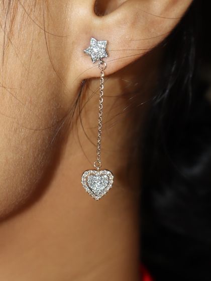 The perfect gift for her: a delicate droplet earring in a heart shape. This piece features a diamond-studded star stud connected to a dangling heart, combining whimsy with elegance.