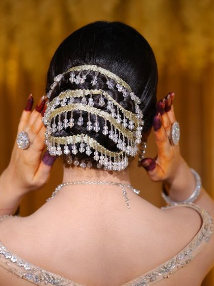 A detailed shot of the elegant bridal bun. Notice the clean sections and the beautiful placement of the hair accessory.