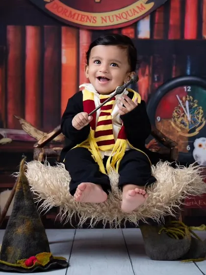A touch of magic makes everything better. Here, a baby enjoys a levitation spell on a broomstick, set against a backdrop that looks straight out of the movies.
